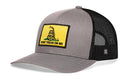 The Haka Hat Don't Tread On Me Trucker Hat is a gray and black snapback with mesh back, featuring a yellow front patch with a coiled snake and “DON’T TREAD ON ME.”.
