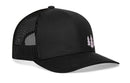 The Haka Hat Three Pine Trees Trucker Hat by Haka Hat is a black snapback with mesh back, curved bill, and small pine tree graphics on the front left for a subtle outdoor vibe.