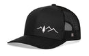 The Haka Hat Pine Tree with Mountains Trucker Hat by Haka Hat is a black mesh outdoors snapback featuring a curved bill and white embroidered pine tree and mountain peaks on the front panel.
