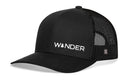 The Haka Hat Wander Trucker Hat is a black outdoors snapback with "WANDER" and a pine tree-shaped A embroidered in white, featuring a curved brim and breathable mesh back for comfortable adventures.