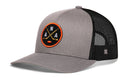 Haka Hat Anaheim Hockey Trucker Hat grey trucker hat with a black mesh back and an ANA X embroidered patch featuring crossed hockey sticks, a puck, and the letters A-N-A.