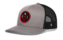 The Haka Hat Chicago Hockey Trucker Hat (CHI X Snapback) features a gray and black design with a circular black and red embroidered patch on the front displaying two crossed bats and the letters C, H, and I. The back is made of breathable black mesh for comfort.