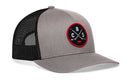 Introducing the Haka Hat Columbus Hockey Trucker Hat | CBS X Snapback by Haka Hat—a gray and black snapback trucker hat featuring a mesh back and a round embroidered CBS X patch on the front. The patch showcases crossed hockey sticks with the letters C, B, and S on a black background outlined in red—the perfect trucker hat for Columbus hockey fans.