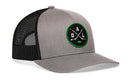 The Haka Hat Dallas Hockey Trucker Hat | DAL X Snapback by Haka Hat is a gray and black mesh trucker snapback hat that features a circular green and black DAL X embroidered patch with crossed hockey sticks and the letters D, A, and L on the front, making it the perfect Dallas hockey hat for fans.
