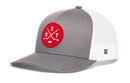 Haka Hat Detroit Hockey Trucker Hat | DET X Snapback in grey and white mesh, featuring a red circular patch with the letters D, E, and T arranged around two crossed hockey sticks and a puck.