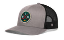 Showcase your love for Minneapolis hockey with the Haka Hat Minnesota Hockey Trucker Hat | MIN X Snapback by Haka Hat. This gray and black mesh trucker features a classic Haka Signature 5.0 style, highlighted by a front patch displaying two crossed hockey sticks, a yellow puck, and the letters M, I, and N on a green background—a standout snapback design that captures the true spirit of Minnesota.