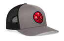 Introducing the Haka Hat Montreal Hockey Trucker Hat | MTL X Snapback by Haka Hat—a gray and black mesh trucker hat featuring a red circular front patch with crossed hockey sticks, a puck, and the letters M, T, and L. It’s the perfect snapback for any Montreal hockey fan.