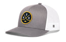 The Haka Hat Nashville Hockey Trucker Hat | NSH X Snapback features a gray and white mesh design with a round black and yellow patch on the front displaying crossed hockey sticks, a puck, and the letters S, N, and H. This Haka Hat combines classic trucker style with modern comfort—perfect for dedicated Nashville hockey fans.