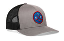 The Haka Hat New York Hockey Trucker Hat | NYC X Snapback is a gray and black mesh snapback featuring a blue and red round patch on the front with crossed hockey sticks, a puck, and the letters N, Y, C.