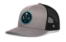 Haka Hat San Jose Hockey Trucker Hat | SJ X Snapback in gray and black, featuring a circular patch with a palm tree above two crossed sticks and the letters S and J.