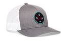 The Haka Hat Seattle Hockey Trucker Hat | SEA X Snapback by Haka Hat is a gray and white mesh snapback featuring a round patch with crossed red hockey sticks, a puck, and the letters S E A on the front—ideal for fans wanting an authentic Seattle hockey trucker hat or looking to expand their signature 5.0 trucker collection.