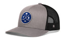 Grey Haka Hat Tampa Bay Hockey Trucker Hat | TB X Snapback with a black mesh back and a circular blue patch featuring a white palm tree, crossed sticks, and the letters T and B.