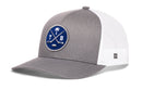 Grey and white Haka Hat Tampa Bay Hockey Trucker Hat featuring a blue circular patch with a palm tree, crossed hockey sticks, a puck, and the letters T and B.