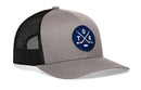 Introducing the Haka Hat Toronto Hockey Trucker Hat | TOR X Snapback—a gray and black snapback trucker hat from Haka Hat, featuring a premium embroidered patch with a round blue design of crossed hockey sticks, the letters T, O, R, and a small hockey puck on the front. It’s the perfect accessory for Toronto hockey fans.