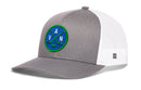 Grey and white Haka Hat Vancouver Hockey Trucker Hat | VAN X Snapback featuring a blue circular patch with crossed hockey sticks, a puck, and the letters V, A, and N.