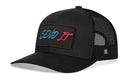 The Haka Hat Send It Trucker Hat in black features a mesh back, comfort-fit sweatband, and a front rectangular patch with SEND IT in blue and red embroidery. Adjustable snapback by Haka Hat.