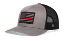The Haka Hat Thin Red Line Trucker Hat in gray and black features a fire tactical American flag patch with a red stripe and breathable black mesh back, all in the signature Haka Hat 5.0 trucker snapback design.