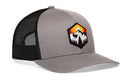 Introducing the Haka Hat Hexagon Mountain Trees Trucker Hat by Haka Hat—a gray and black adventure hat with a mesh back, featuring a hexagon patch on the front that displays mountains, trees, and a sunset. This outdoors snapback is perfect for your next adventure.