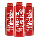 Three bottles of Redneck Lipstick Hot & Spicy Three Pack BBQ Sauce stand side by side on a white background. The bold labels, featuring the Redneck Lipstick brand name in white and black text along with a Real Good badge at the top, showcase this Hot & Spicy BBQ Sauce made with authentic cayenne flavor.