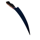 The Spaceman Knives Galaxy Series Boning Knife by Spaceman Knives features a large curved black blade and a marbled dark and gold handle, shown on a light wooden surface—perfect for precision meat preparation.
