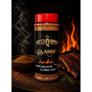 A bottle of Scott’s Smoked Q Classic Dry Rub Sweet Smoky All-Purpose BBQ Seasoning sits beside a bowl of spices and smoked ribs, with flames and smoke in the background. The label reads “Maryland Born, Florida Made.” This seasoning from Scott’s Smoked Q is a sweet and smoky dry rub that’s perfect for elevating all your BBQ dishes.
