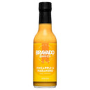 A bottle of Bravado Spice Co Pineapple & Habanero Hot Sauce from Bravado Spice Co, featuring a black cap, yellow label with white text, and labeled as 8 fl oz (148 ml). This tropical hot sauce offers medium heat.