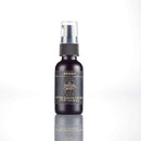 A small dark bottle labeled “Bright After Shave Lotion” with a spray cap stands upright on a reflective white surface, serving as the ideal finishing touch to The Immaculate Beard’s Immaculate Premium Wet Shaving Kit for Men with Ceramic Bowl and Soap.
