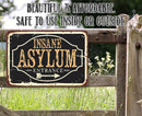 The Lone Star Art Insane Asylum Metal Sign adds humor to your decor. Displayed on a wooden fence amid grass, this durable Halloween sign is perfect for indoor or outdoor use and offers affordable, rustic style.