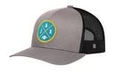 Introducing the Haka Hat Jacksonville Trucker Hat—a black and gray football snapback from Haka Hat featuring a mesh back and a distinctive circular JAX X embroidered patch with a yellow-bordered blue background, crossed yellow lines, bold white “JAX” lettering, and a small football icon. Perfect for any football snapback collection.