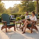 A man and woman relax on Kanyon Living Kanyon Poly Folding Adirondack Chairs in Dark Green and Cedar Wood, enjoying coffee in a sunny garden. The woman reads beside a small table with a plant; colorful flowers and greenery surround them.