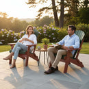 A man and woman relax and chat on Kanyon Living’s Kanyon Poly Folding Adirondack Chairs in Dark Green & Cherry Wood. With a small table between them, they enjoy the comfort and style of this quality outdoor furniture on a sunny patio.
