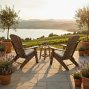 Two Kanyon Living Poly Folding Adirondack Chairs in Light Grey & Weathered Wood and a small table sit on a stone patio overlooking a vineyard and lake, surrounded by potted lavender, trees, and sunlight in this peaceful outdoor setting.