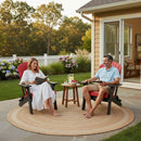 A man and woman relax and read on Kanyon Living's Kanyon Poly Folding Adirondack Chairs in Red and Black, Amish-crafted from recycled poly lumber, set on a patio with drinks, snacks, flowers, and trees nearby.