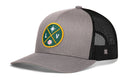 Introducing the Haka Hat Las Vegas Baseball Trucker Hat | LV X Snapback by Haka Hat—a stylish gray and black mesh snapback hat featuring a round green and gold embroidered LV X patch with an asterisk, the letters L and V, and a small baseball at its center. This classic trucker hat design combines comfort with an adjustable fit for everyday wear.