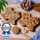 Two Medium Texas Pecan Cakes from Texas Pecan Cakes are artfully displayed on a cutting board, accompanied by a bowl of whole pecans, a scoop of brown sugar, and a “1st Place Winner—QUEST FOR TEXAS BEST” blue ribbon badge, celebrating the authentic taste of Texas. Ideal for anyone who loves the iconic Texas Pecan Cake or traditional pecan cakes, this 2-pack serves 10-12 and brings true Lone Star flavor to your table.