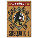 The Lone Star Art "Do Not Feed Sasquatch" metal sign features a Sasquatch silhouette, rustic background, house graphic, and the warning: Please Do Not Feed The Sasquatch—perfect for bigfoot decor.