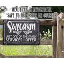 A rustic fence showcases the Lone Star Art "Sarcasm Just One Of The Many - Metal Sign" with the quote, “Sarcasm. Just one of the many services I offer.” Safe for indoor/outdoor use. Green grass and plants in the background.