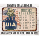 The Lone Star Art USA Military Alphabet - Metal Sign showcases saluting soldiers, an eagle emblem, and the American flag. Made of aluminum, it’s a perfect military gift that won’t rust, fade, or peel.