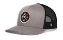 The Haka Hat New Orleans Trucker Hat features a black mesh back, round patch with crossed lines, "NOLA," and football graphic. This classic snapback by Haka Hat offers signature trucker style in black and gray.