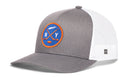 Haka Hat New York Hockey Trucker Hat in gray and white, featuring a circular patch with a blue background, crossed hockey sticks, a puck, and the letters N and Y.