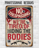 Add bold humor to your decor with the No Trespassing Tired of Hiding The Bodies - Metal Sign by Lone Star Art, featuring bullet holes, blood spatters, and rifle silhouettes. Perfect for gun enthusiasts!.