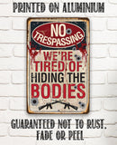 The No Trespassing Tired of Hiding The Bodies - Metal Sign by Lone Star Art is a rustproof, fade-resistant gun-themed decor with dark humor—ideal for warning trespassers with style.
