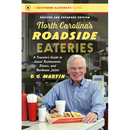 A smiling man sits at a diner table laden with classic Southern food—fries, a burger, drinks, and a red ketchup bottle—all evoking the warm atmosphere of North Carolina roadside eateries. In front of him is the book “North Carolina's Roadside Eateries, Revised and Expanded Edition: A Traveler's Guide to Local Restaurants, Diners, and Barbecue Joints - Paperback” by Books by splitShops.