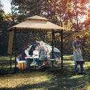 Four people at a campsite: three sit at a table under the DirectDeals 13.5 x 4 Feet Patio BBQ Grill Gazebo Canopy with Dual Side Awnings, chatting and eating, while one cooks nearby. Sunlight filters through trees and a tent is in the background.