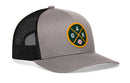 Introducing the Haka Hat Oakland Baseball Trucker Hat | OAK X Snapback by Haka Hat—a stylish gray and black trucker hat with a breathable mesh back. The front showcases a circular green and yellow patch featuring the letters “OAK” and a small baseball graphic, making it the perfect hat for Oakland baseball fans.