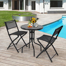 A modern white building and grass frame a cozy scene: the DirectDeals 5 Pieces Patio Rattan Furniture with 2 Ottomans and Tempered Glass Coffee Table-Red is arranged by the pool, decorated with sunflowers, fruit, and drinks.