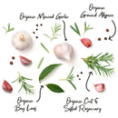 Whole garlic bulbs and cloves, bay leaves, rosemary sprigs, and allspice berries are arranged on a white background. Handwritten labels point to items from The Spice Lab Organic Spice Complete Collection – 30 Jars by The Spice Lab. This USDA certified organic set is a premium addition to any organic spice collection.