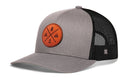 Introducing the Haka Hat Outdoor X Trucker Hat, a stylish gray and black snapback from Haka Hat. Featuring a mesh back and a round brown patch on the front adorned with four adventure-inspired symbols—a tree, mountains, water, and a tent—this Black Outdoor X Snapback is perfect for your next outdoor adventure.