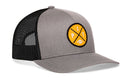 The Haka Hat Pittsburgh Football Trucker Hat | Yellow PIT X Snapback by Haka Hat features a gray and black mesh design with a bold yellow circular patch on the front. The patch showcases black lines forming an X, with the letters P and I at the top and bottom and a small football graphic at the base—making this Yellow PIT X Snapback the perfect trucker hat for any Pittsburgh football fan.