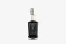A glass bottle of Taycte Acetaia Malpighi Platinum IGP High-Density Balsamic Vinegar of Modena, aged over 25 years, from the brand Taycte, featuring a silver cap and an intricate black-and-white label with text and logos, displayed against a plain white background.